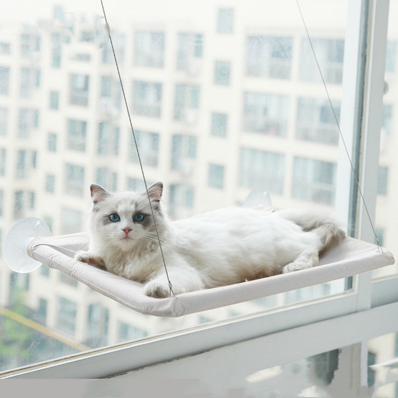 Witte raamhangmat met zuignappen aan het raam met een ragdollkat erin