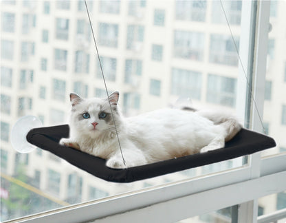 Zwarte raamhangmat met zuignappen aan het raam met een kat die naar buiten kijkt